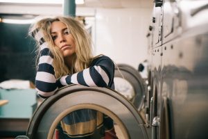 Woman at laundrette frustrated as washing machine not draining